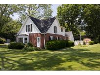 Charming two-story home featuring a combination of brick and siding, complemented by a lush green lawn and mature trees at 980 W Poplar St, Zionsville, IN 46077