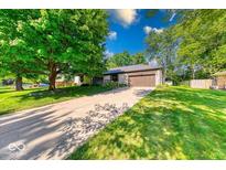 Charming ranch home with a spacious front yard, large tree, and an attached two-car garage at 11 N Restin Rd, Greenwood, IN 46142