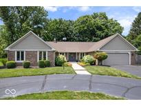 Charming ranch-style home with a brick facade, mature trees, and an attached two-car garage at 12674 Banbury Cir, Carmel, IN 46033