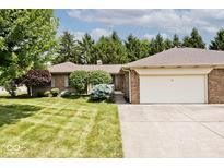 Charming brick home with manicured lawn, mature trees, and attached garage. The home's number is visible above the garage at 13 Marywood Dr, Greenfield, IN 46140