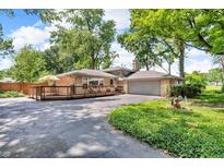 Back exterior of home featuring large deck, well-maintained lawn and mature trees at 1340 Eustis Dr, Indianapolis, IN 46229