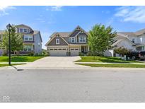 Charming two-story home with three-car garage and landscaped yard on a sunny day at 15813 Arthur Jacob Ln, Noblesville, IN 46060
