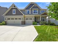 Beautiful two-story home featuring a three-car garage and manicured front lawn on a sunny day at 15813 Arthur Jacob Ln, Noblesville, IN 46060