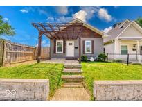 Charming home featuring a wooden pergola, neutral siding, and well-maintained front yard at 1641 Deloss St, Indianapolis, IN 46201