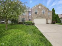 Lovely two-story brick home boasting a spacious front lawn and three-car garage at 1680 Woodfield Dr, Greenwood, IN 46143