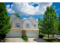 Charming townhouse with a two-car garage, lovely landscaping and inviting curb appeal on a beautiful, sunny day at 1856 Misty Lake Dr, Indianapolis, IN 46260