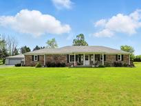 Charming brick home featuring a well-manicured lawn and inviting covered porch at 1981 N Valley Ln, Greenfield, IN 46140