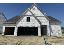 New construction home featuring Tyvek home wrap, an attached garage, and a newly installed roof in a suburban neighborhood at 19990 Stone Side Dr, Westfield, IN 46074