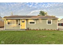 Charming single-story home with a well-manicured lawn and a bright yellow front door at 2563 Harlan St, Indianapolis, IN 46203
