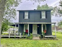 Two-story home featuring a covered porch with outdoor seating and a white front door at 3190 S Tacoma Ave, Indianapolis, IN 46237