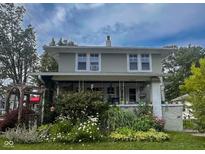Charming two-story home with covered porch and lush front garden at 430 W Locust St, Shelbyville, IN 46176