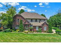 Beautiful brick home with manicured lawn, mature trees, and lush landscaping at 4704 Pearcrest Way, Greenwood, IN 46143