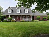 Charming red brick home featuring a welcoming front porch and meticulously maintained lawn, perfect for curb appeal at 6118 Yellow Birch Ct, Avon, IN 46123