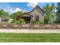 Charming home with a quaint front yard, decorative fence, and inviting curb appeal under a sunny sky at 718 E Washington St, Lebanon, IN 46052