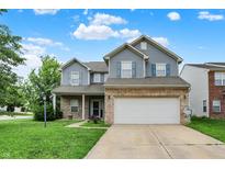 Charming two-story home featuring blue siding, brick accents, well-manicured lawn, and an attached two-car garage at 8212 Twin River Dr, Indianapolis, IN 46239