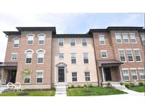 Charming brick townhouses feature well-maintained landscaping and inviting entrances at 954 Yorkshire Ln, Zionsville, IN 46077