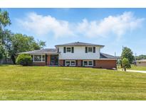 Charming two-story home with a well-maintained lawn and classic curb appeal on a sunny day at 1011 Robin Dr, Anderson, IN 46013