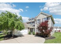 Charming two-story home featuring a stone facade, large driveway, and well-manicured lawn at 12404 Guy Way, Indianapolis, IN 46236