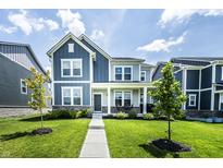Charming two-story home with a well-manicured lawn, inviting porch, and modern design at 14404 Stairbridge Pl, Carmel, IN 46074