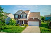Inviting two-story home with brick and siding, featuring a well-manicured lawn and attached two-car garage at 14620 Hinton Dr, Fishers, IN 46037