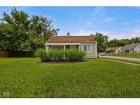 Charming home featuring a cozy, covered front porch and well-maintained lawn at 1730 S State Ave, Indianapolis, IN 46203