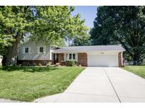 Charming home featuring a brick facade, siding, well-manicured lawn, and an attached two-car garage at 218 Narcissus Dr, Indianapolis, IN 46227