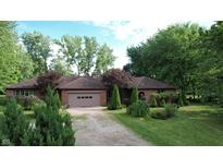 Charming ranch home features a brick facade, attached garage, and lush landscaping at 3711 Tara Ct, Carmel, IN 46074