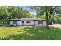 Charming ranch-style home with freshly painted white brick, black trim, and lovely, landscaped yard at 4305 Five Points Rd, Indianapolis, IN 46239