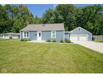 Charming blue home with a well-maintained lawn and a detached two-car garage at 5902 Oak Ln, Anderson, IN 46013
