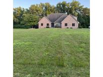 Lovely brick home featuring a sprawling green lawn and mature trees creating a serene and private setting at 5993 E County Road 100 S, Avon, IN 46123