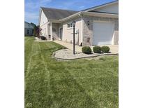 Beautiful brick home with a well-maintained lawn and attached garage at 712 Disciples Way, Greenwood, IN 46143