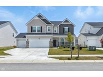 Charming two-story home features a two-car garage, stone accents, and a well-manicured front lawn at 7301 Deerberg Dr, Indianapolis, IN 46259