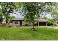 Charming single-story home with well-manicured lawn and mature shade trees at 11230 N College Ave, Carmel, IN 46032