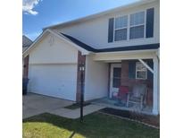 Two-story home featuring an attached garage and a cozy front porch seating area at 11985 Cat Tail Ct, Noblesville, IN 46060