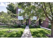 Inviting two-story brick home with manicured lawn and lush landscaping creates stunning curb appeal at 1311 Central Ave, Indianapolis, IN 46202