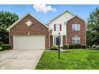 Charming two-story home features a brick facade, attached garage, and well-maintained lawn at 13264 Penneagle Dr, Carmel, IN 46033