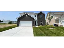 Charming two-story home with a brick facade, attached garage, and well-maintained lawn at 164 Luna Pl, Shelbyville, IN 46176