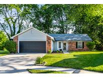 Charming single-story home with brick accents, lush lawn, mature trees, and a convenient two-car garage at 1657 Park Terrace Ct, Indianapolis, IN 46229
