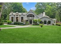 Charming home featuring lush lawn, manicured landscaping, stone accents, and architectural details at 1805 Wood Valley Dr, Carmel, IN 46032
