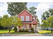 Charming two-story home featuring a red exterior, white trim, and inviting front porch at 2015 N College Ave, Indianapolis, IN 46202