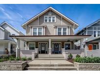 Inviting two-story duplex with a charming front porch, perfect for relaxing outdoors on a sunny day at 2332 Central Ave, Indianapolis, IN 46205