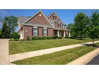 Charming two-story brick home with a well-manicured lawn and mature landscaping at 3853 Abney Highland Dr, Zionsville, IN 46077