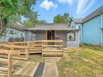 Charming home featuring accessible wooden ramp leading to lattice-covered porch at 405 Harlan St, Indianapolis, IN 46201