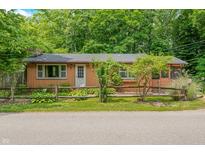 Charming exterior view of a cozy home with a quaint fence and lush greenery at 5052 Helmsburg School Rd, Morgantown, IN 46160