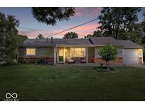 Charming single-story home features a well-manicured lawn, neutral siding, and cozy front porch at 5672 W New York St, Indianapolis, IN 46224