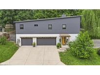 Modern two-story home featuring a gray exterior, two-car garage, and vibrant yellow front door at 5903 Birchwood Ave, Indianapolis, IN 46220
