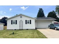 Well-maintained single-story home features a garage, manicured lawn, and inviting curb appeal at 6408 W Taylor Rd, Muncie, IN 47304
