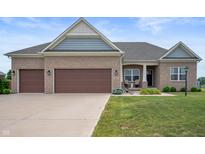 Charming single-story brick home featuring a well-manicured lawn and a three-car garage at 6420 Colt Ln, Anderson, IN 46013