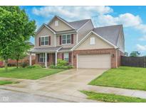 Beautiful two-story home featuring a brick and vinyl exterior, attached two-car garage, and well-manicured lawn at 6589 Kara Ln, Brownsburg, IN 46112