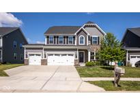 Charming two-story home with a three-car garage, manicured lawn, and beautiful architectural details at 7128 Verwood Ct, Plainfield, IN 46168